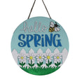 Decorative sign with 'hello SPRING' text and a bee, flowers, and fence design, hanging on a glass door.